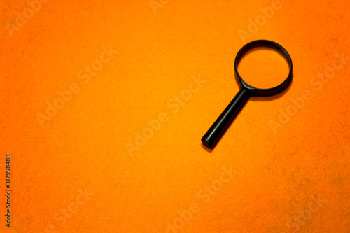 Magnifier glass on an orange background, concept, business.