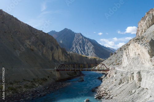 An old iron hanging suspension bridge Overpass Crossing over mountain river valley on a background of hills. Geographical border area remote location, Kaza Himachal Pradesh India South Asia Pac