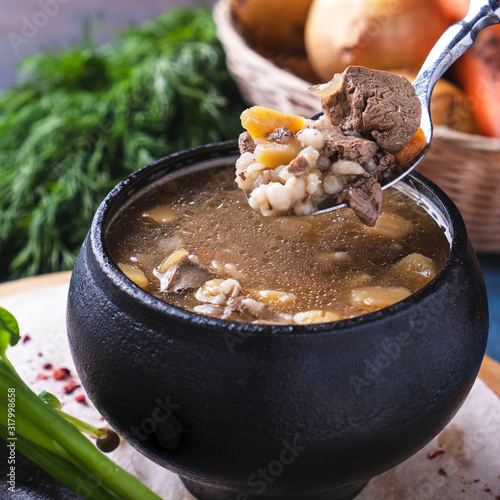 Tasty soup with meat and mushroom  in a pot. Closeup