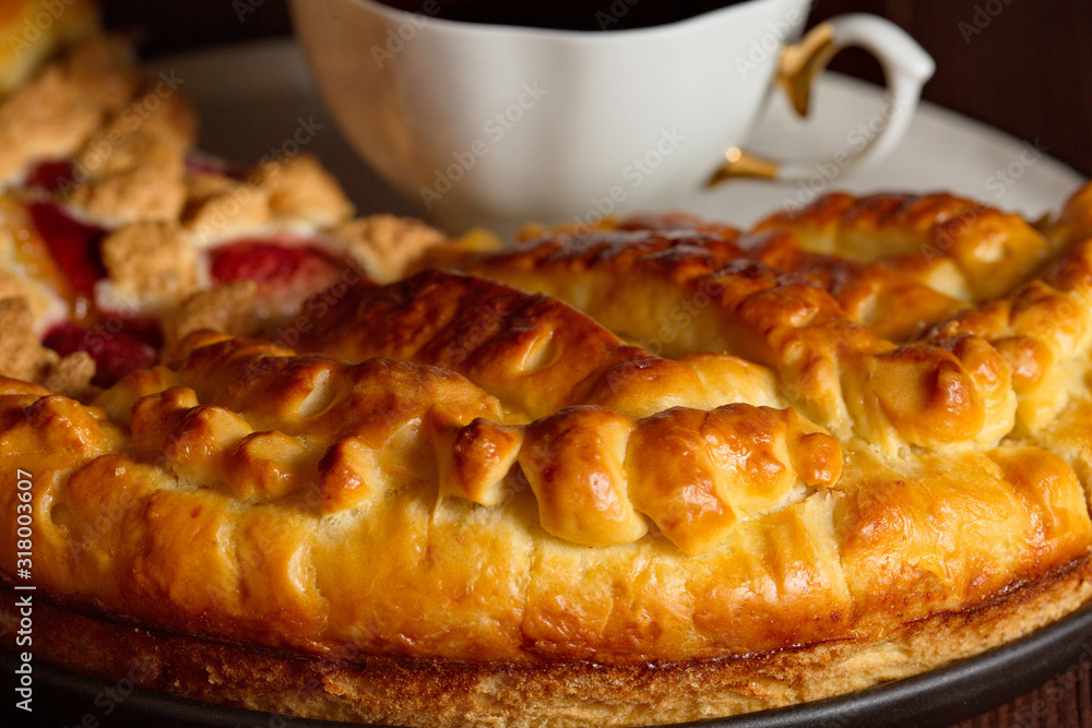 Delicious lemon pie is on a large white plate. Close up. Very tasty homemade cakes. Cup of fragrant tea. Delicious lemon pie is on a large white plate. Close up. Very tasty homemade cakes. Cup of fragrant tea.