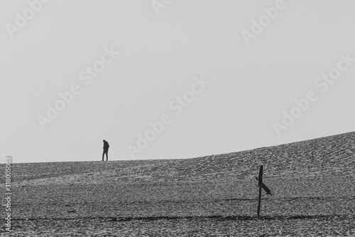Man walking alone in the desert sand