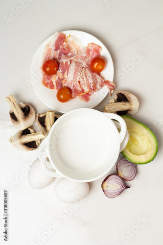 breakfast ingredients: eggs and vegetables, bacon and mushrooms