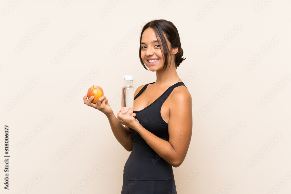 Young brunette girl with an apple and with a bottle of water over isolated background Young brunette girl with an apple and with a bottle of water over isolated background