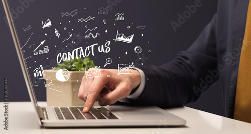 Businessman working on laptop with CONTACT US inscription, modern business concept