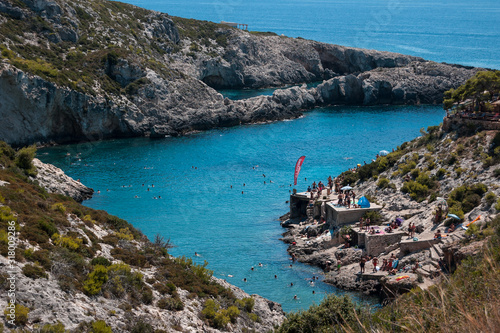 Rocky beach seashore on Zakynthos with people swimming
