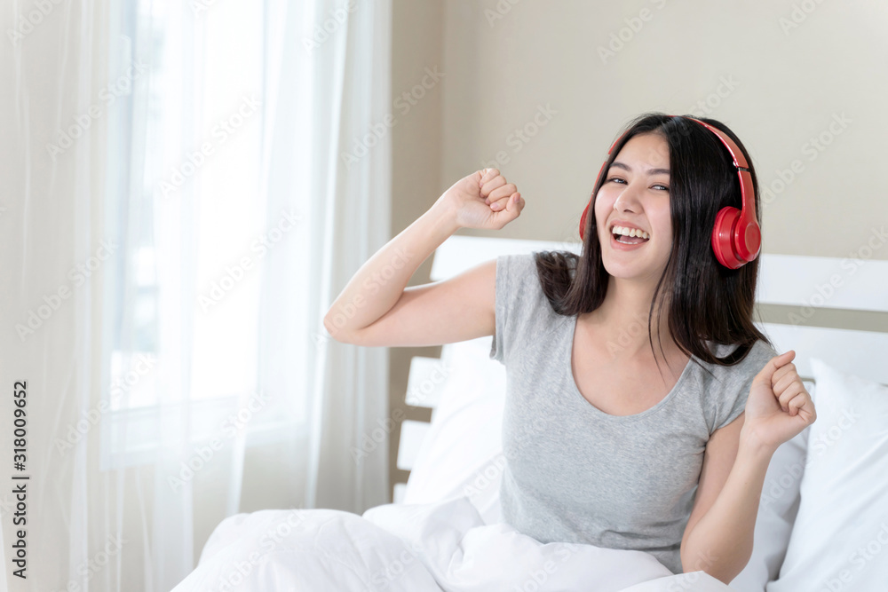 Asian pretty teenage woman wearing red bluetooth headphone, Dance and smiley for listening music with joyful, copy space Asian pretty teenage woman wearing red bluetooth headphone, Dance and smiley for listening music with joyful, copy space