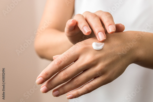 closeup view of woman hands applying hand cream. beauty shot