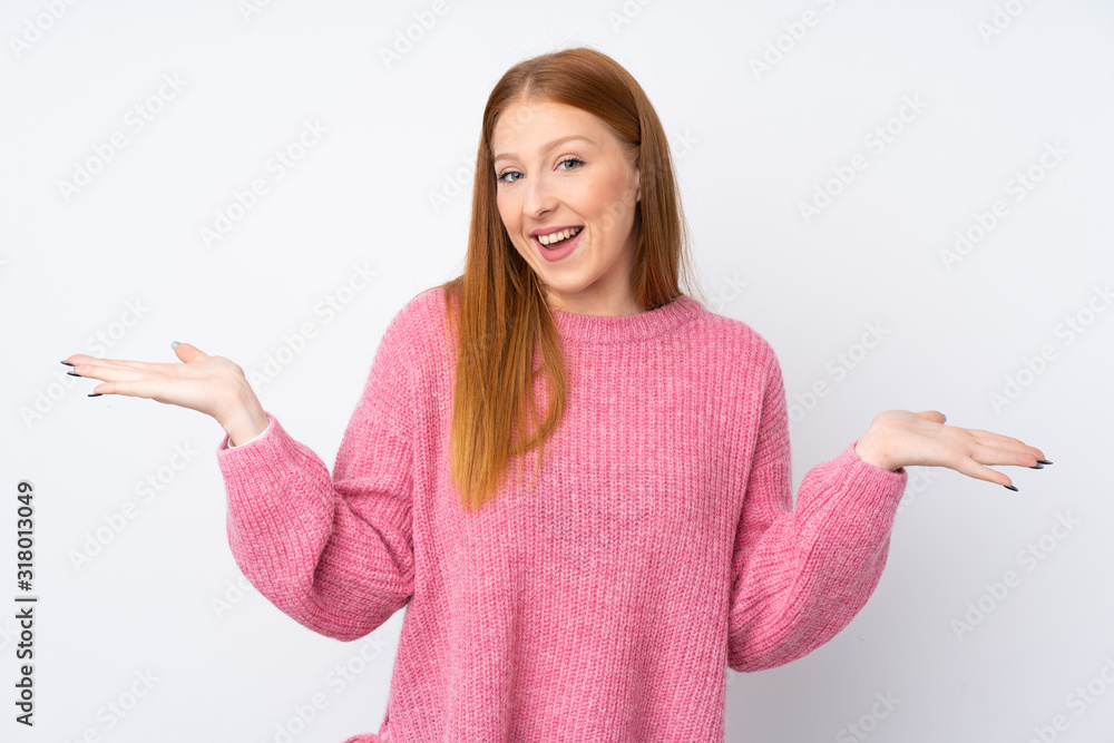 Young redhead woman with pink sweater over isolated white background with shocked facial expression Young redhead woman with pink sweater over isolated white background with shocked facial expression
