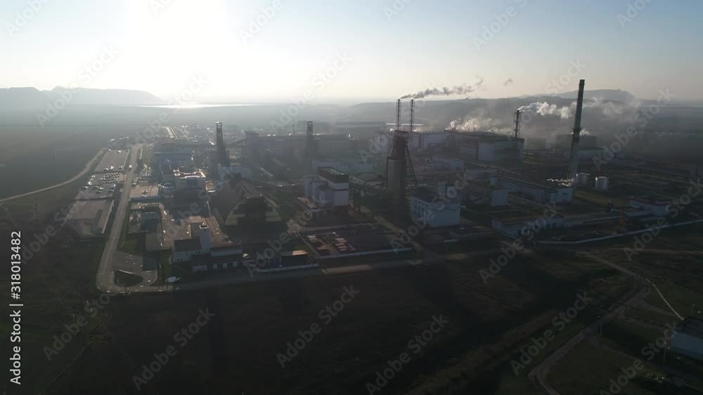 Potash plant for the extraction of potash fertilizers, mountains of waste near the plant, smoke from pipes, shooting from a height, flying up Potash plant for the extraction of potash fertilizers, mountains of waste near the plant, smoke from pipes, shooting from a height, flying up