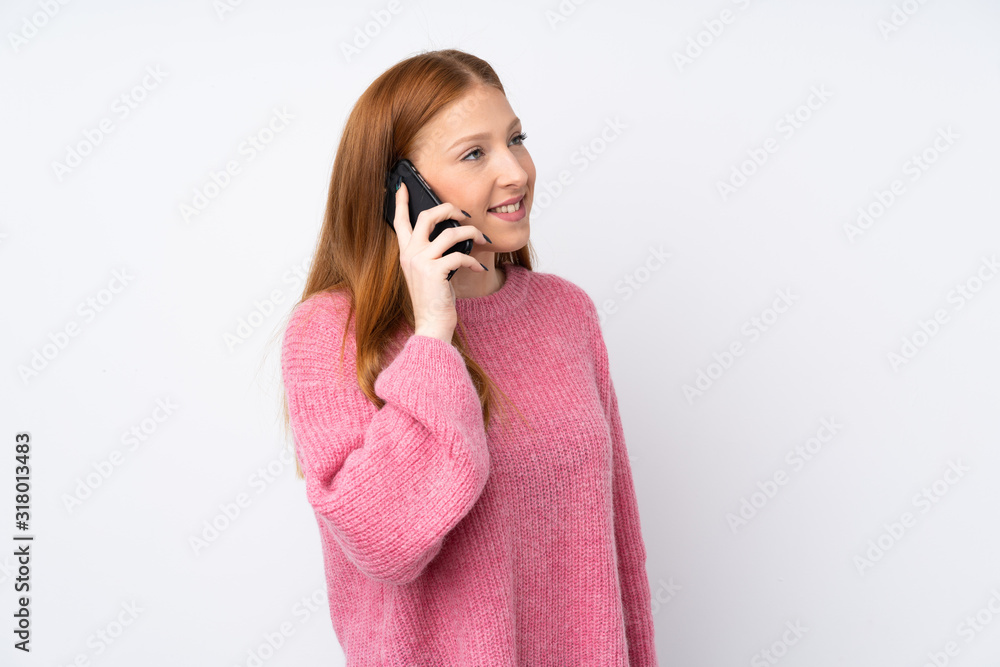 Young redhead woman with pink sweater over isolated white background keeping a conversation with the mobile phone with someone Young redhead woman with pink sweater over isolated white background keeping a conversation with the mobile phone with someone