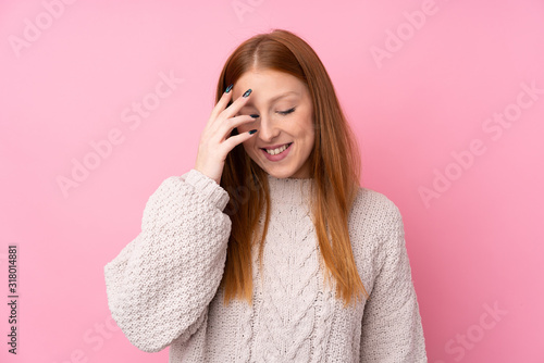 Young redhead woman over isolated pink background laughing