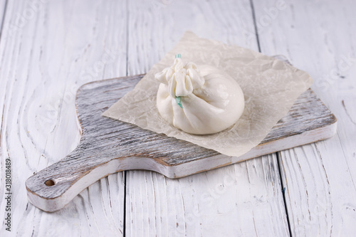 Burrata cheese bag on wooden background