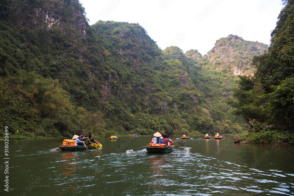 Tourist are traveling by sitting on the rowing boat in the river,  Ninh Binh, Vietnam.