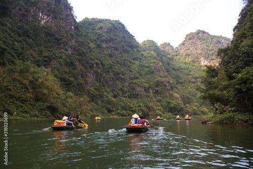 Tourist are traveling by sitting on the rowing boat in the river,  Ninh Binh, Vietnam. © May_Chanikran