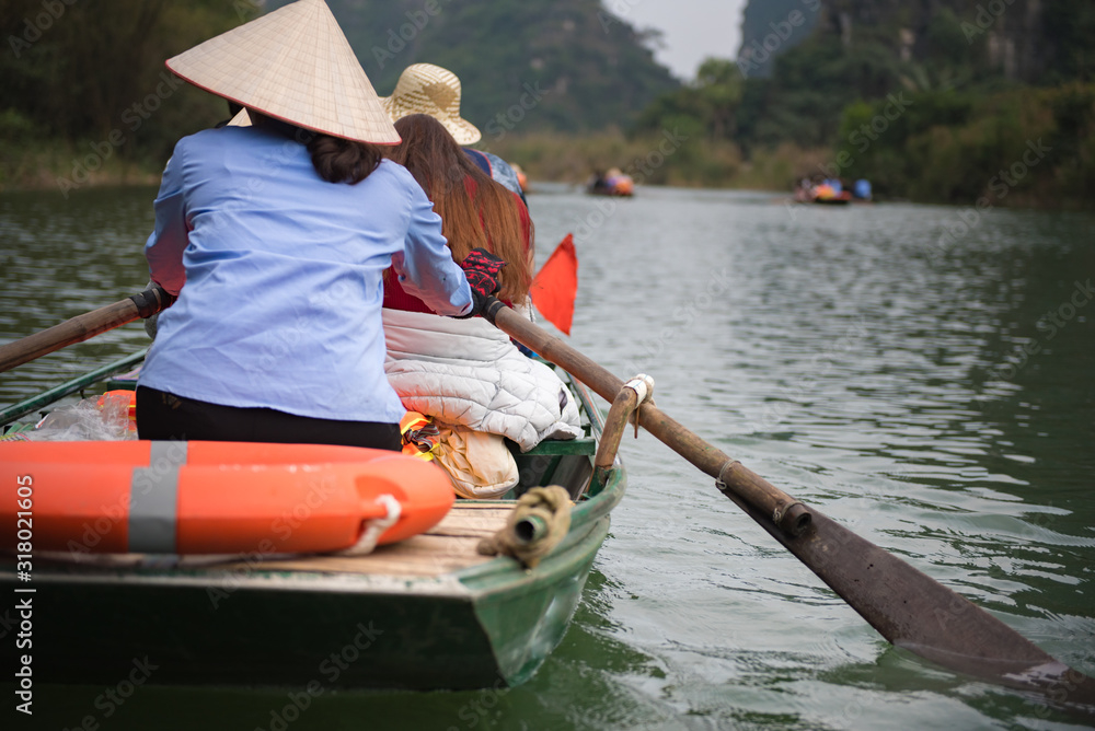 Tourist are traveling by sitting on the rowing boat in the river,  Ninh Binh, Vietnam.