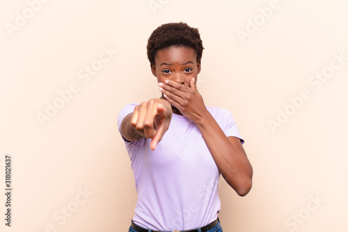 young pretty black womanlaughing at you, pointing to camera and making fun of or mocking you photo