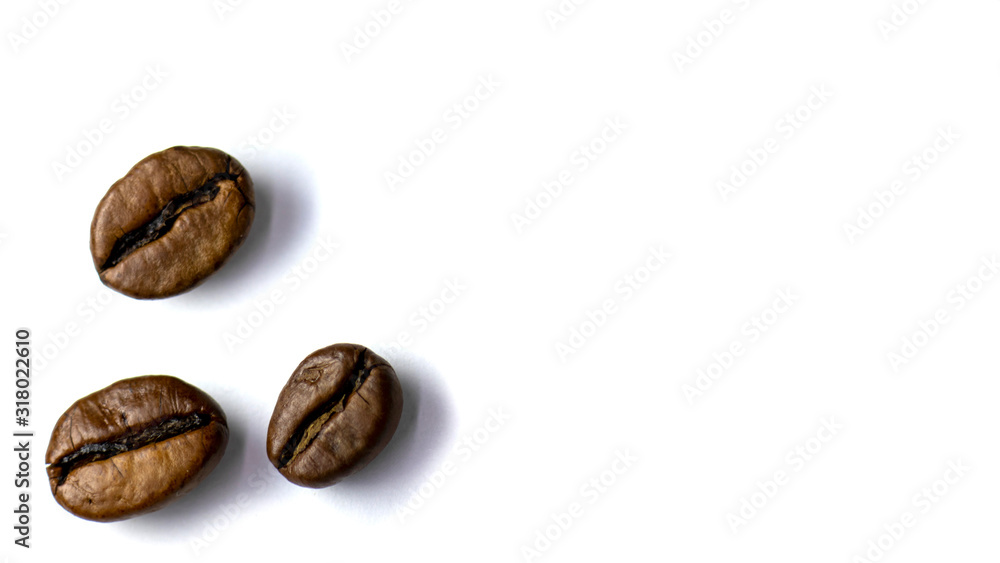 Background of three coffee beans, roasted coffee beans with selective focus on a white background, space for text. Background of three coffee beans, roasted coffee beans with selective focus on a white background, space for text.
