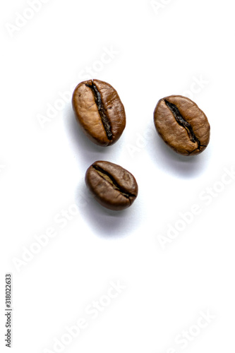 Background of three coffee beans  roasted coffee beans with selective focus on a white background  space for text.