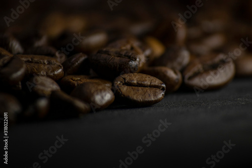 Coffee in beans on dark background. Abstract background texture.Coffee beans texture. Food background of coffee beans