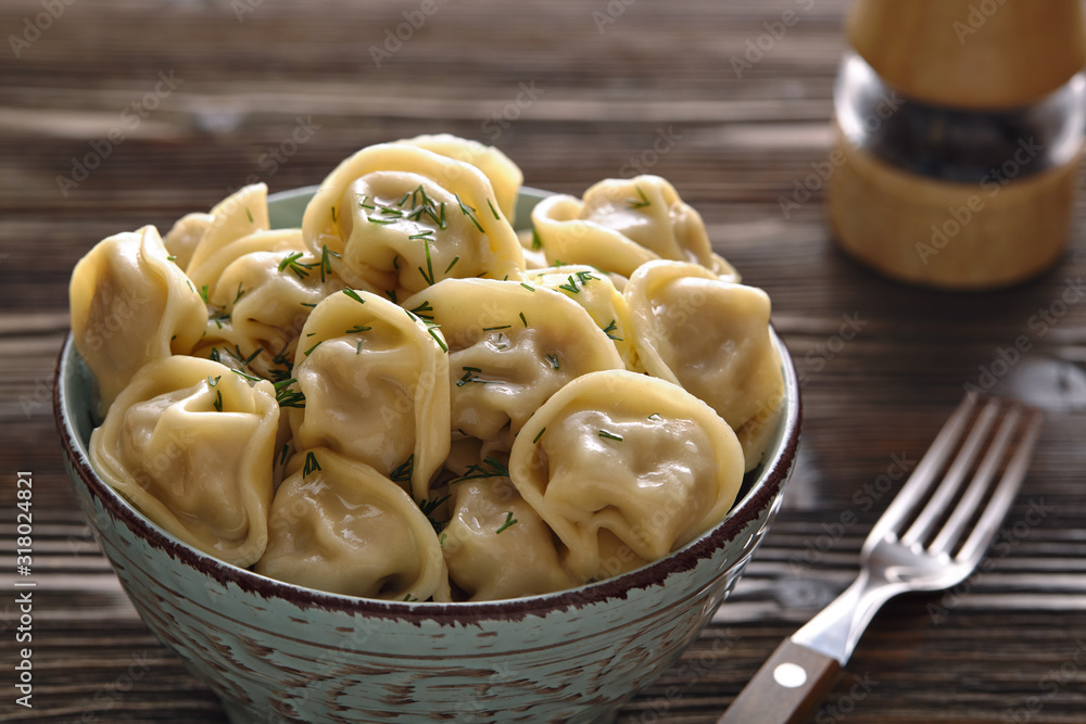 Plate of traditional Russian dumplings, ravioli on a dark wooden background.