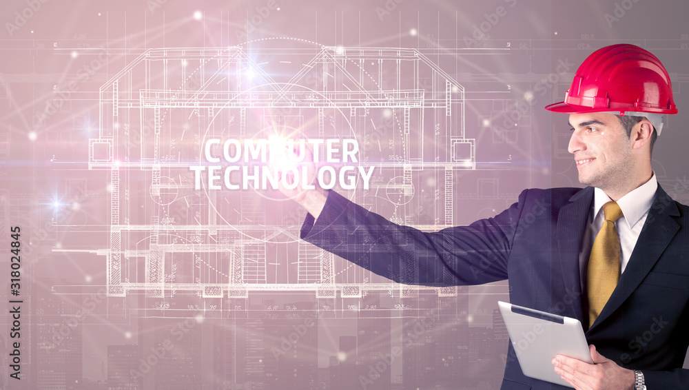 Handsome architect with helmet drawing COMPUTER TECHNOLOGY inscription, new technology concept Handsome architect with helmet drawing COMPUTER TECHNOLOGY inscription, new technology concept
