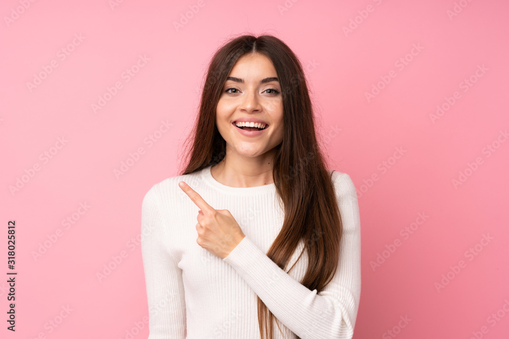 Young woman over isolated pink background pointing finger to the side Young woman over isolated pink background pointing finger to the side