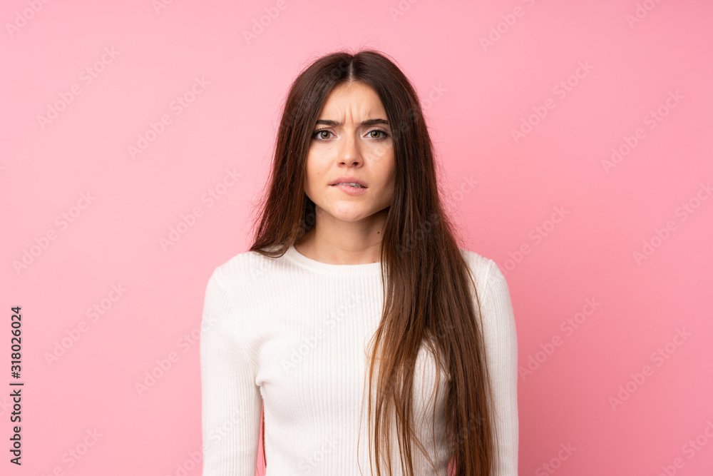 Fototapeta premium Young woman over isolated pink background having doubts and with confuse face expression