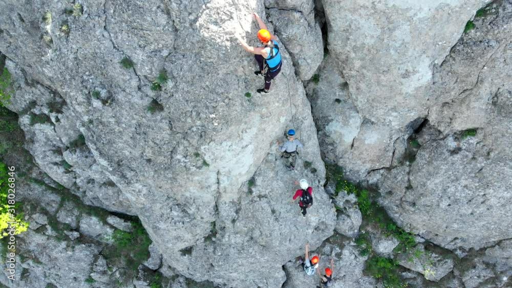 Aerial view of people climbing on rock. Summer sports and active lifestyle concept. Adrenaline, strenght, ambition. Male rock climber training outdoor in summer. Aerial view of people climbing on rock. Summer sports and active lifestyle concept. Adrenaline, strenght, ambition. Male rock climber training outdoor in summer.