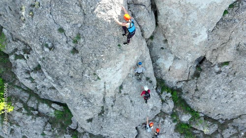 Aerial view of people climbing on rock. Summer sports and active lifestyle concept. Adrenaline, strenght, ambition. Male rock climber training outdoor in summer.