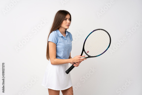 Young girl over isolated white wall playing tennis © luismolinero