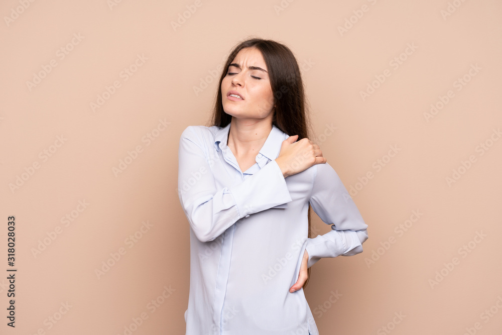 Young woman over isolated background suffering from pain in shoulder for having made an effort Young woman over isolated background suffering from pain in shoulder for having made an effort