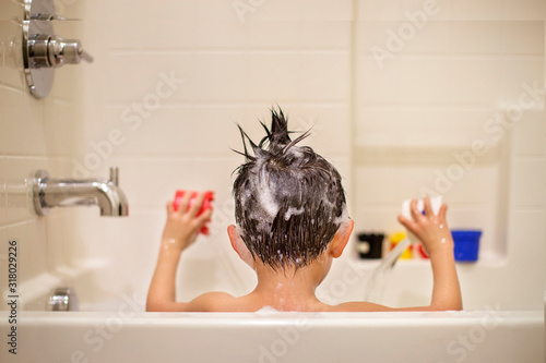 little boy playing with toys in a bathtub photo