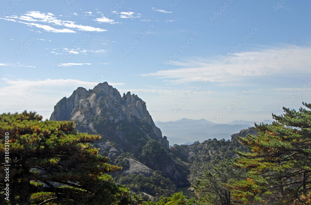 Huangshan Mountain in Anhui Province, China. View of Lotus Peak from Bright Top. This is the highest peak and true summit of Huangshan. Scenic view of peaks and trees on Huangshan Mountain, China.