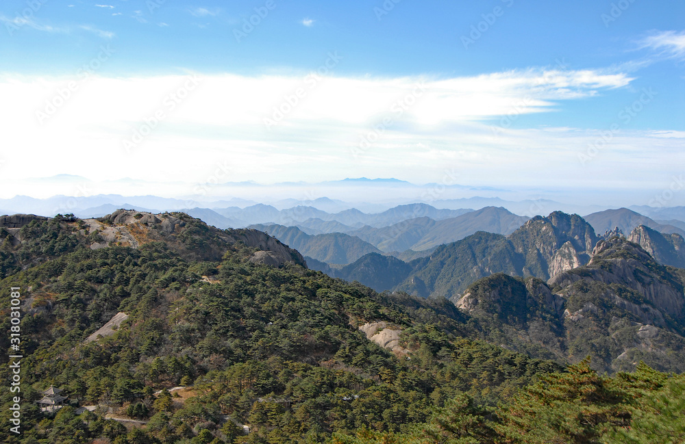 Huangshan Mountain in Anhui Province, China. View of Turtle Peak on left and other mountain peaks from Bright Top viewpoint. Scenic view of peaks and trees on Huangshan Mountain, China.