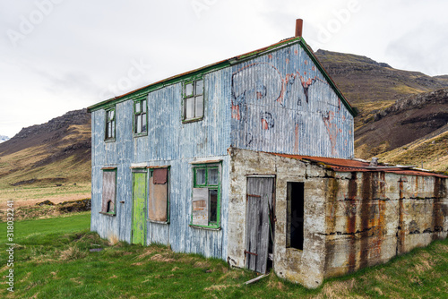Blue abandoned and rusty farmhouse. Near Djupivogur in Iceland next to the ring road during road trip. Building and architecture concept. photo