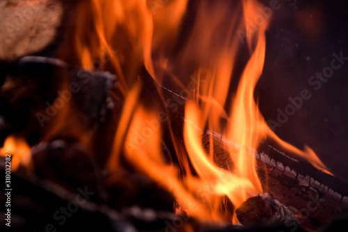 firewood burns in a red flame during a fire.