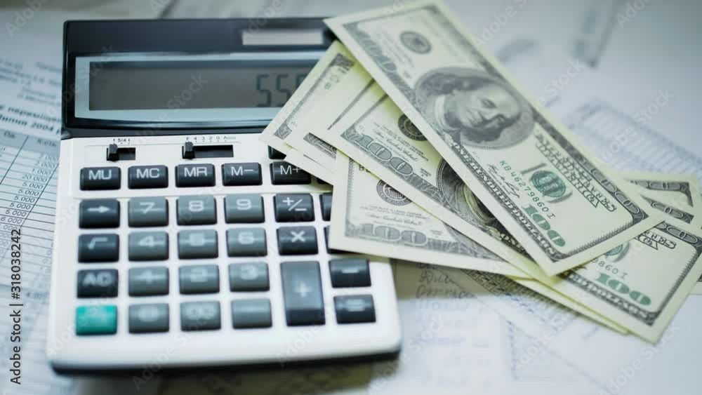 Calculator And Money - Accounting Concept. Slow motion of falling american dollar bills. Calculator And Money - Accounting Concept. Slow motion of falling american dollar bills.