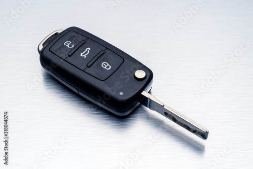 New car key fob on aluminium background. Repair of broken or damaged remote key fob of any vehicle car service concept.- Image photo