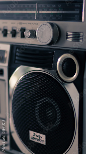 Parlante de un equipo de música portátil de los años 80 en primer plano y aislado. Tenue luz sobre la escena. Leve tono en sepia sobre la fotografía. Tecnología vintage y retro. photo