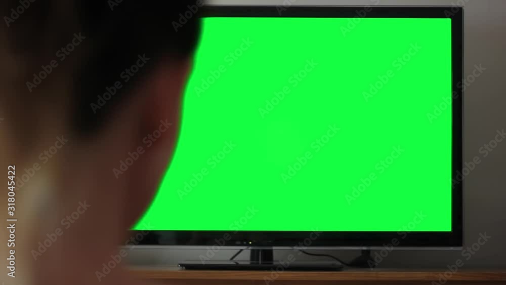 Woman Watching a TV with Green Screen at Home. Woman Watching a TV with Green Screen at Home.