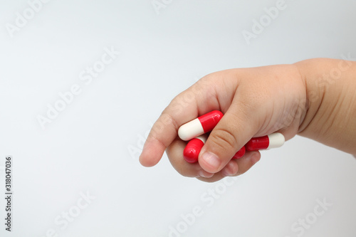 pills in baby hand isolated on white background
