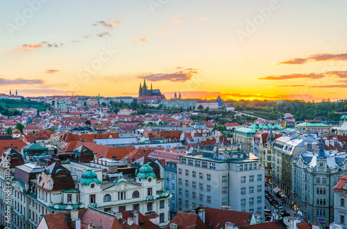 Top aerial panoramic view of Prague Old Town historical city centre with red tiled roof buildings and Prague Castle, St. Vitus Cathedral in Hradcany district in evening sunset, Bohemia, Czech Republic
