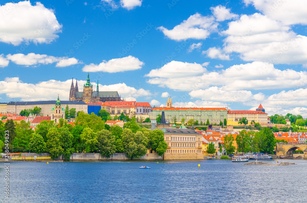View of Prague old town, historical center with Prague Castle, St. Vitus Cathedral in Hradcany district, Vltava river, blue sky white clouds background, Bohemia, Czech Republic