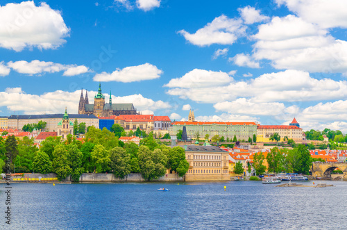 View of Prague old town, historical center with Prague Castle, St. Vitus Cathedral in Hradcany district, Vltava river, blue sky white clouds background, Bohemia, Czech Republic