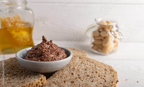 Homemade organic vegan chocolate spread, made of almonds, honey and cacao. With a jar of rice milk