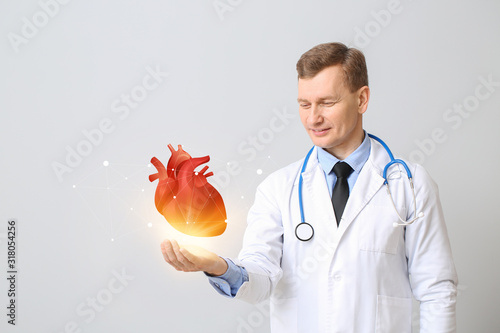 Male cardiologist holding d...
