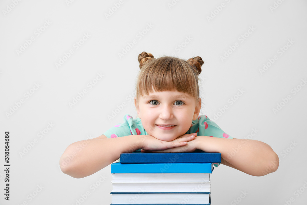 Cute little girl with books on light background Cute little girl with books on light background