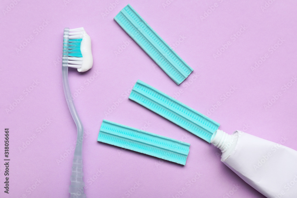 Tooth brush with paste and chewing gums on color background Tooth brush with paste and chewing gums on color background