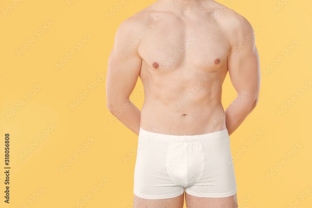 Fototapeta premium Handsome man in underwear on color background