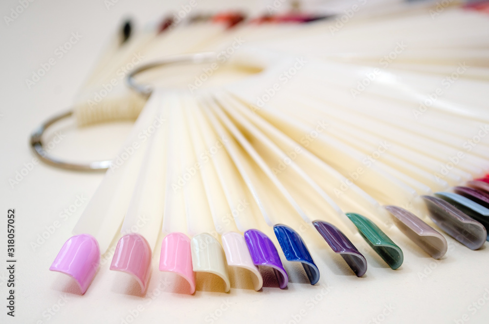 Palette of nail designs of different colors with gel polish on a white tips and background. Collection of plastic testers for nail polish Palette of nail designs of different colors with gel polish on a white tips and background. Collection of plastic testers for nail polish